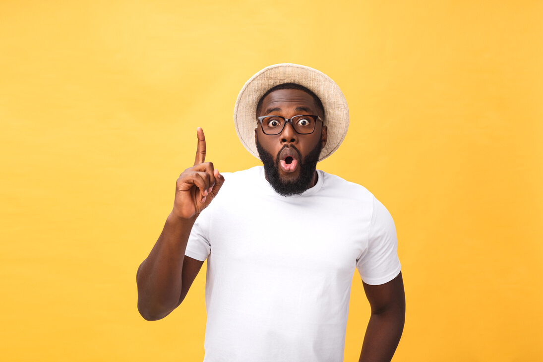 Young African American Man over Yellow Background Pointing Upwards